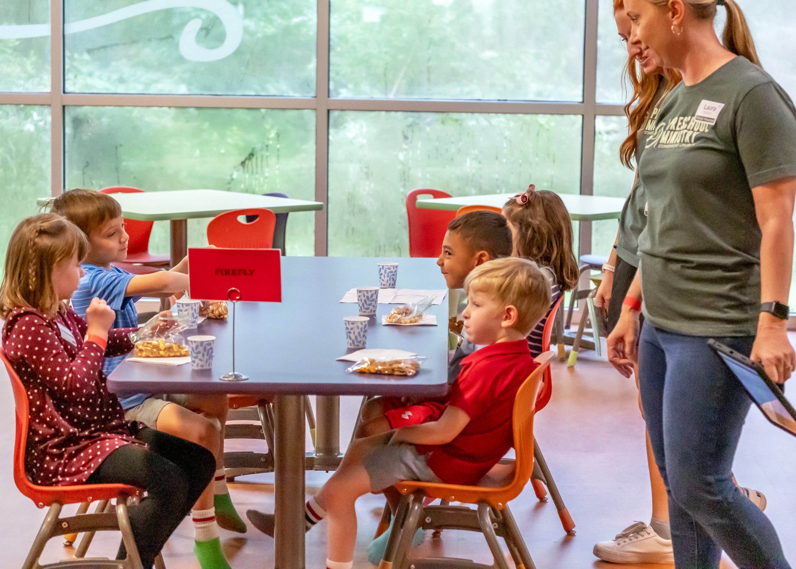 Preschool kids eating a snack in the children's building.